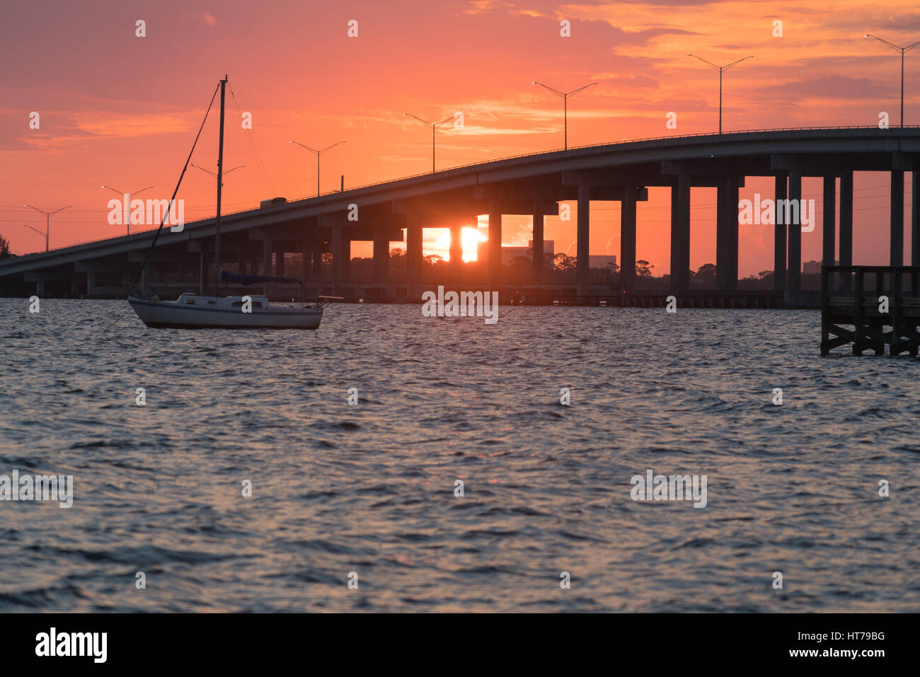 The Sun Rises behind the Eau Gallie Causeway Bridge between Melbourne's mainland and the barrier island and beaches Stock Photo