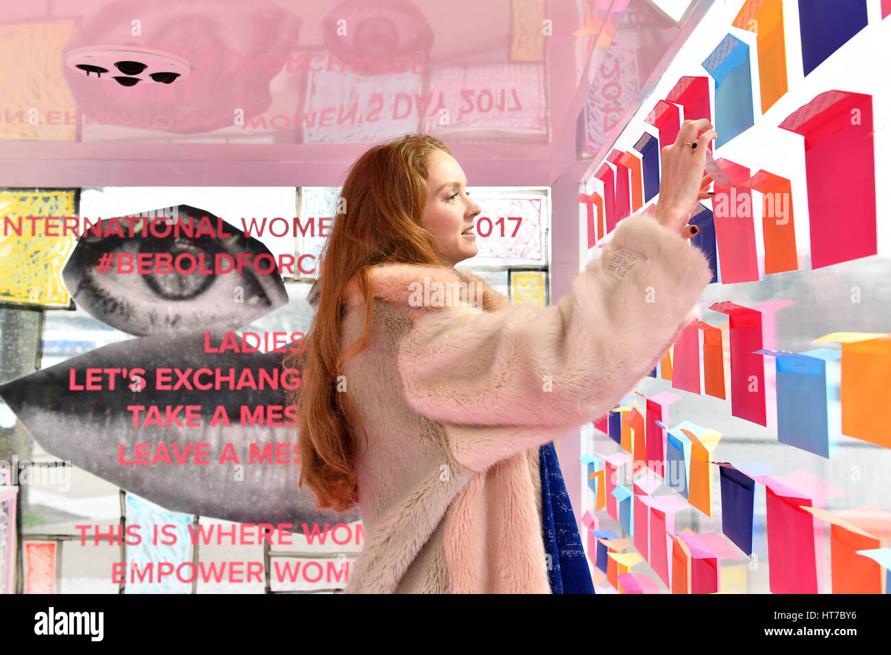 EDITORIAL USE ONLY Lily Cole leaves a message to inspire other women at the #beboldforchange art installation for International Women&Otilde;s Day, which has been created by artist couple Charlotte and Philip Colbert and commissioned by Tinder, at Observation Point on London&Otilde;s Southbank. Stock Photo