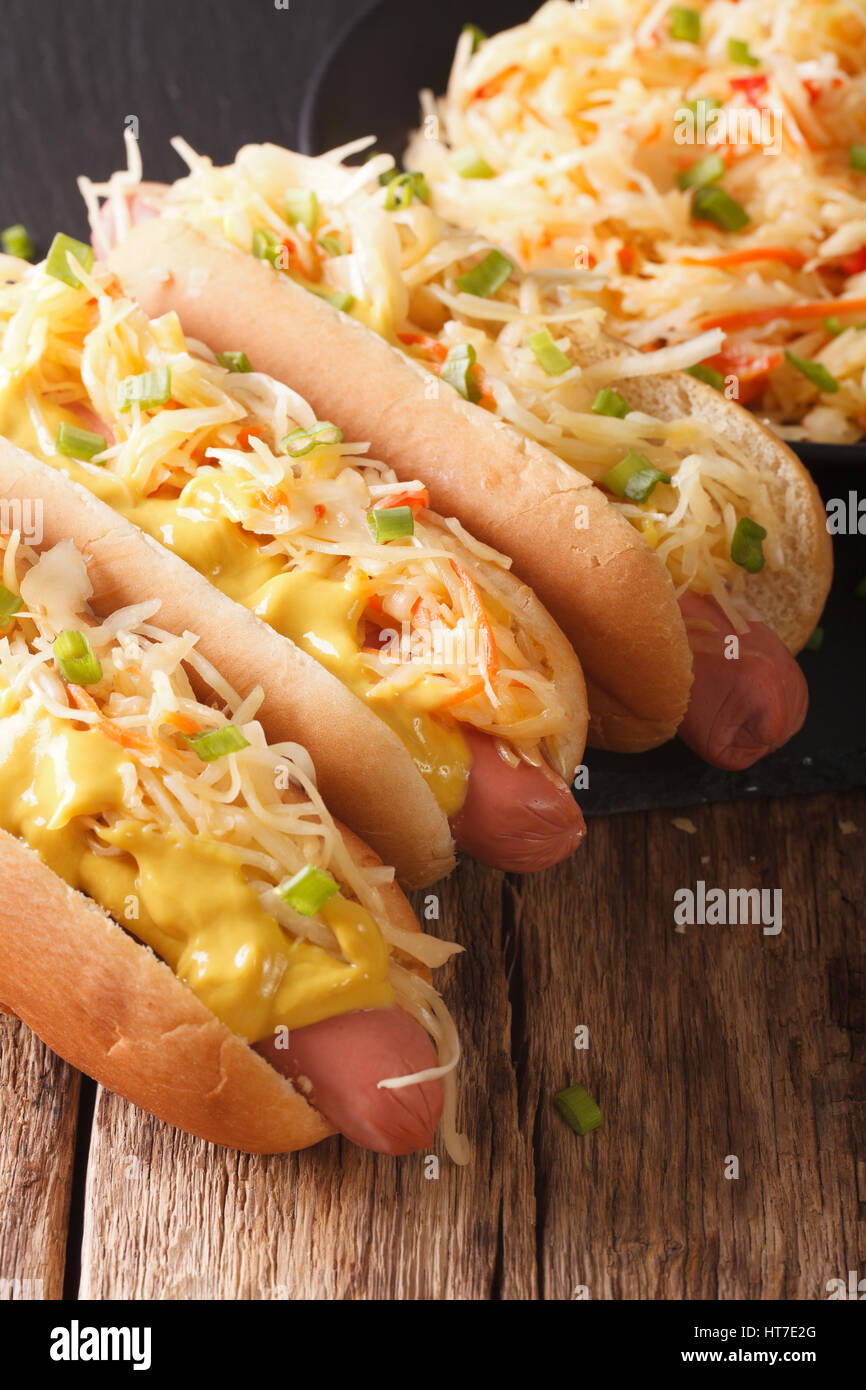 Delicious hot dog with sausage, sour cabbage and mustard closeup on