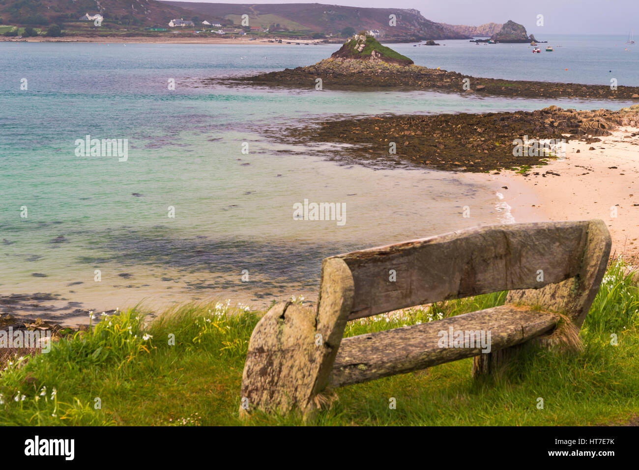 bench looking out to sea with views of Bryher/Bryer and uninhabited islands at Tresco, Isles of Scilly, Scillies, Cornwall in April Stock Photo