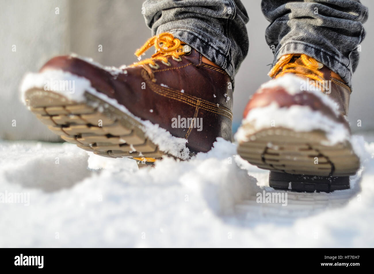Brown leather shoes in the snow. Legs in the warmth concept Stock Photo
