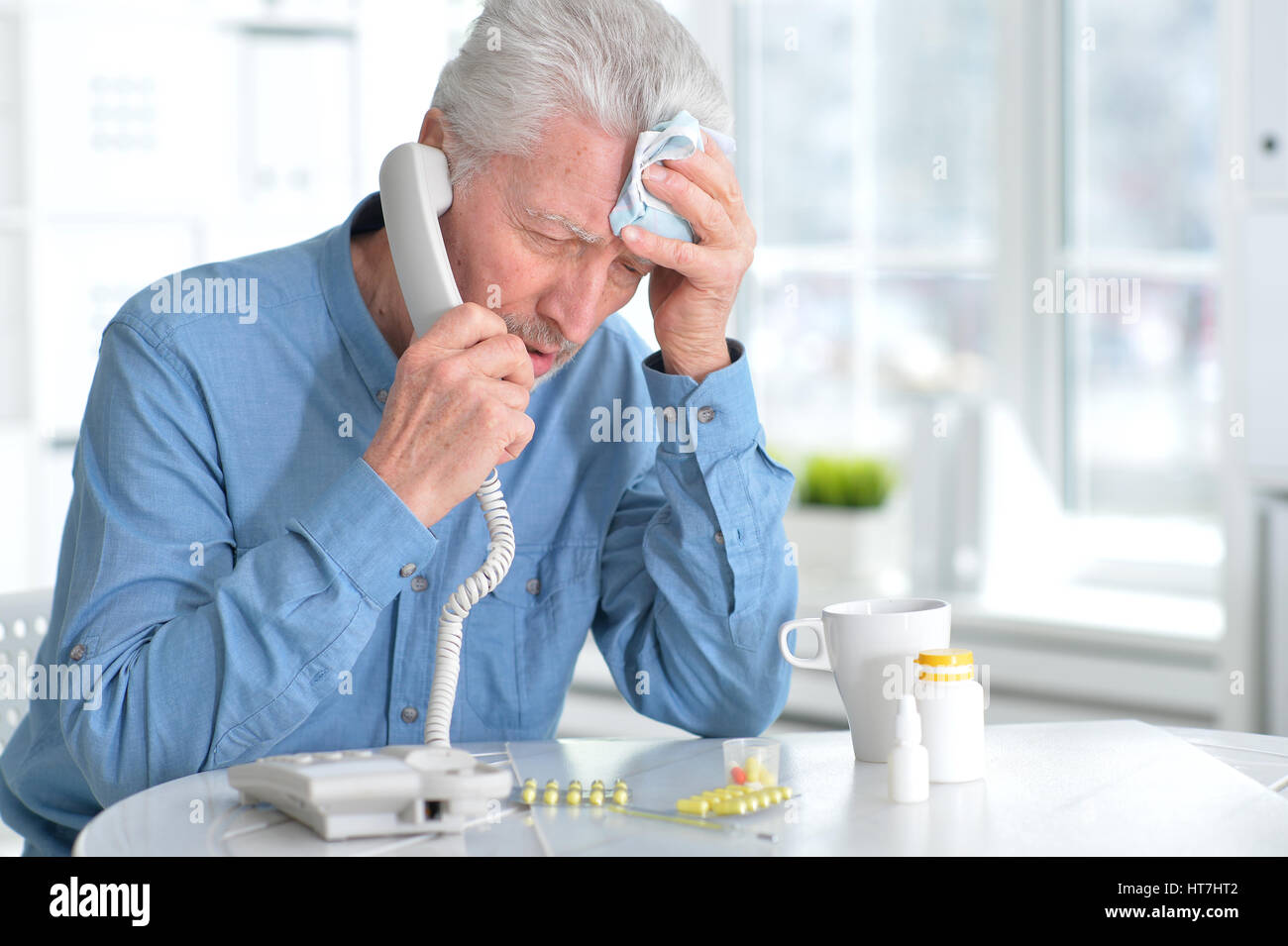 Sick elderly man calling by phone Stock Photo