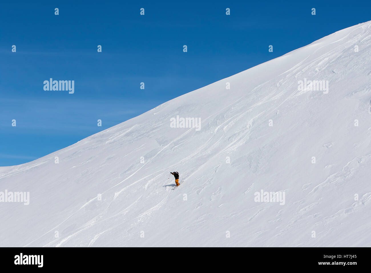 A Skier Straight Lines Over Other Tracks And Puts His Hands Up In The Air In Excitement In The Backcountry Around Cerro Catedral In Argentina Stock Photo