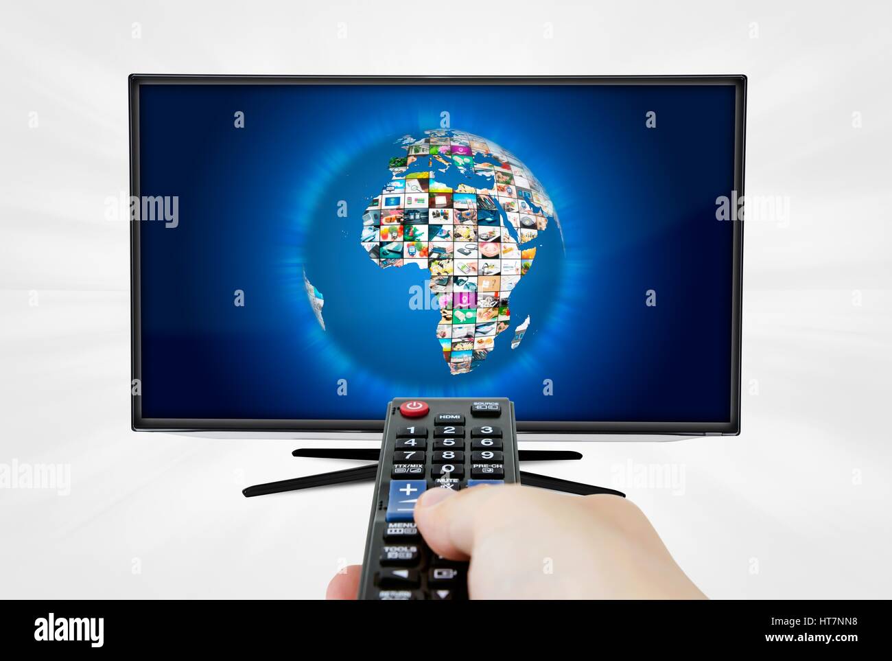 Widescreen high definition TV screen with sphere video gallery. Remote control in hand Stock Photo