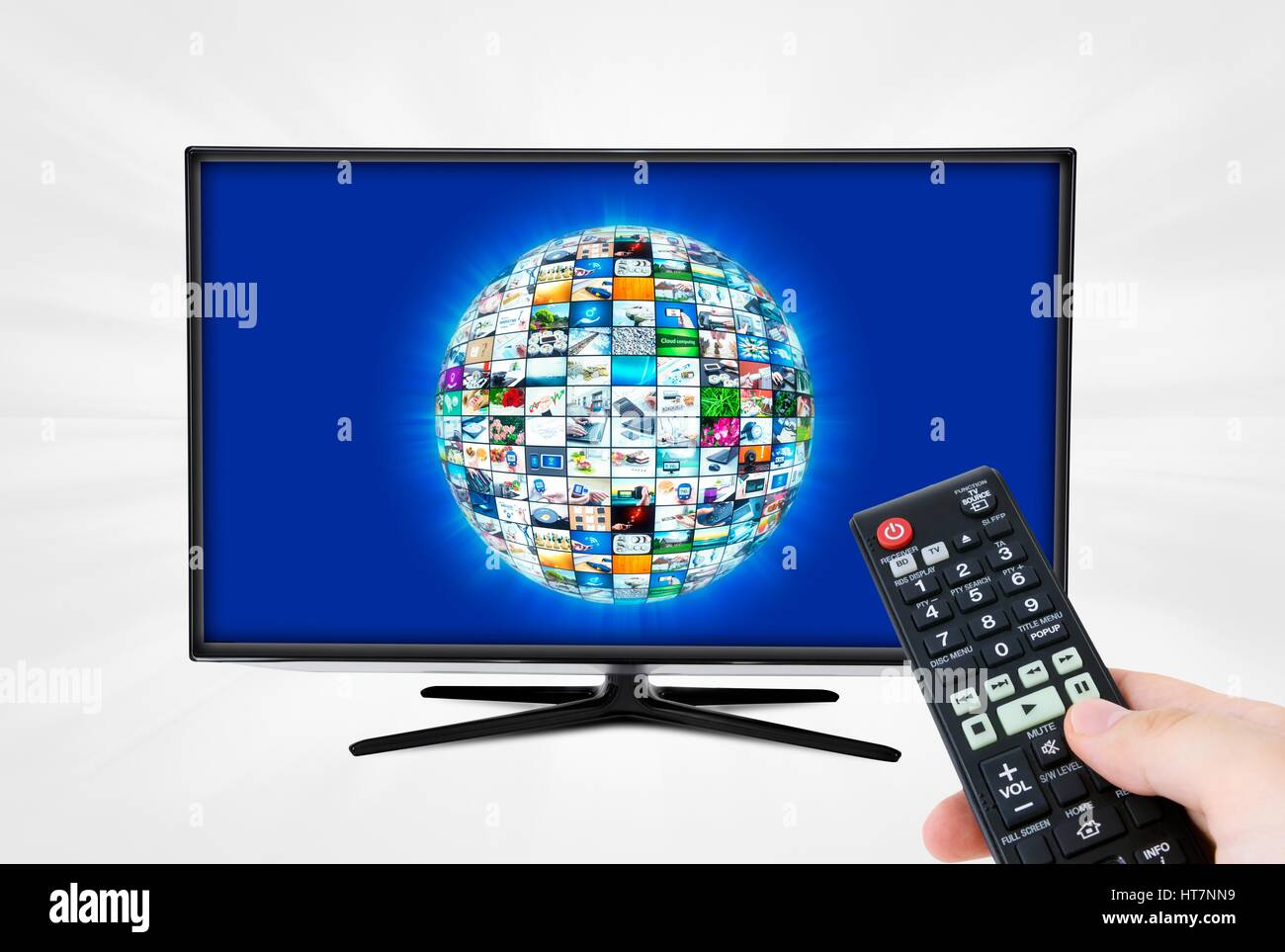 Widescreen high definition TV screen with sphere video gallery. Remote control in hand Stock Photo