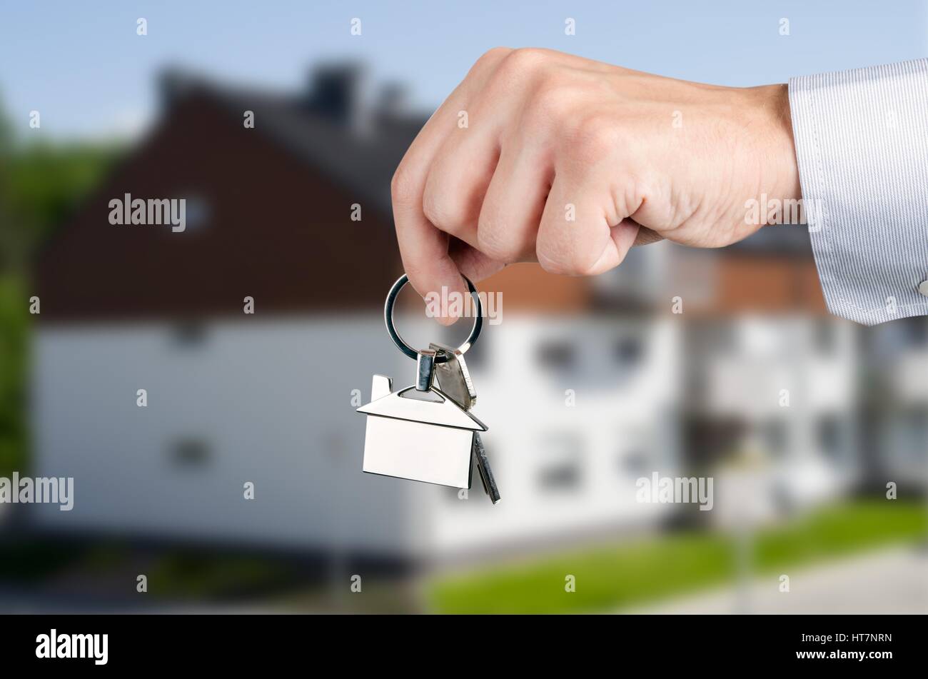 Man hand holding keys with to new house. Home shape chrome pendant ...