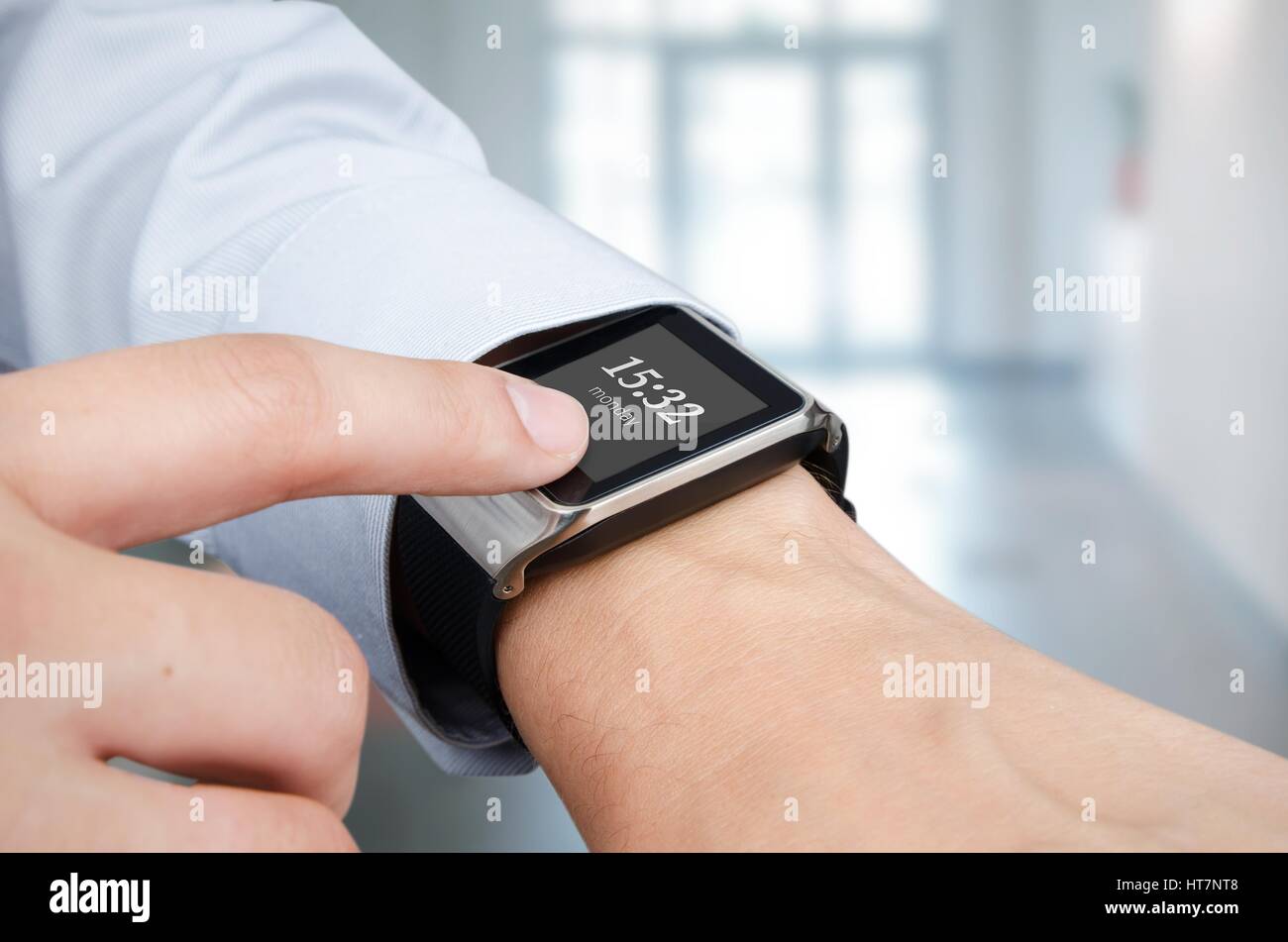 Businessman checking time on modern smart watch. Office in background Stock Photo