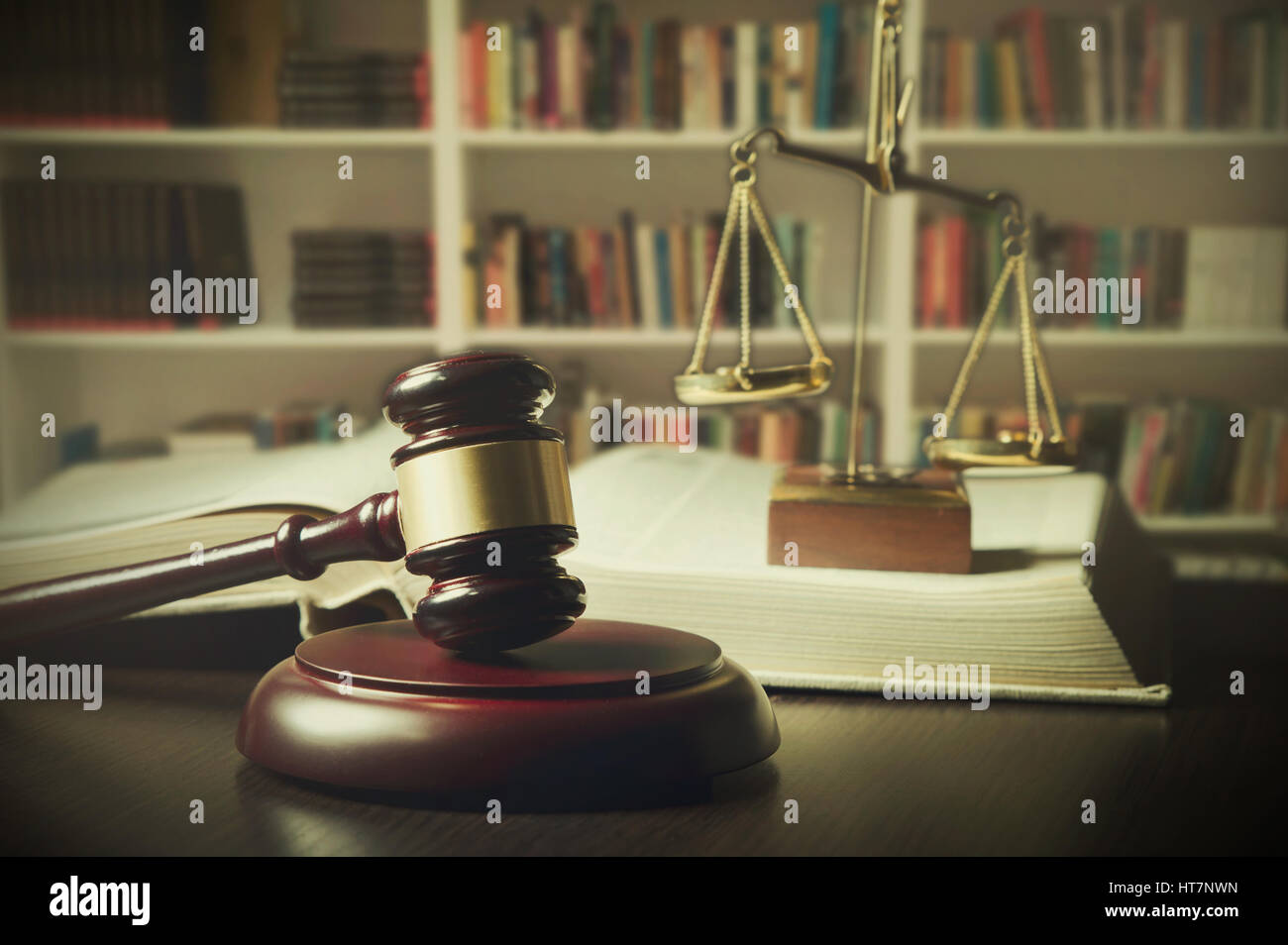 Judge gavel and scale in court. Library with lot of books in background Stock Photo