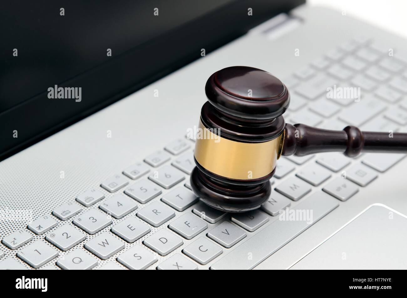 Wooden judge hammer on laptop computer white keyboard Stock Photo