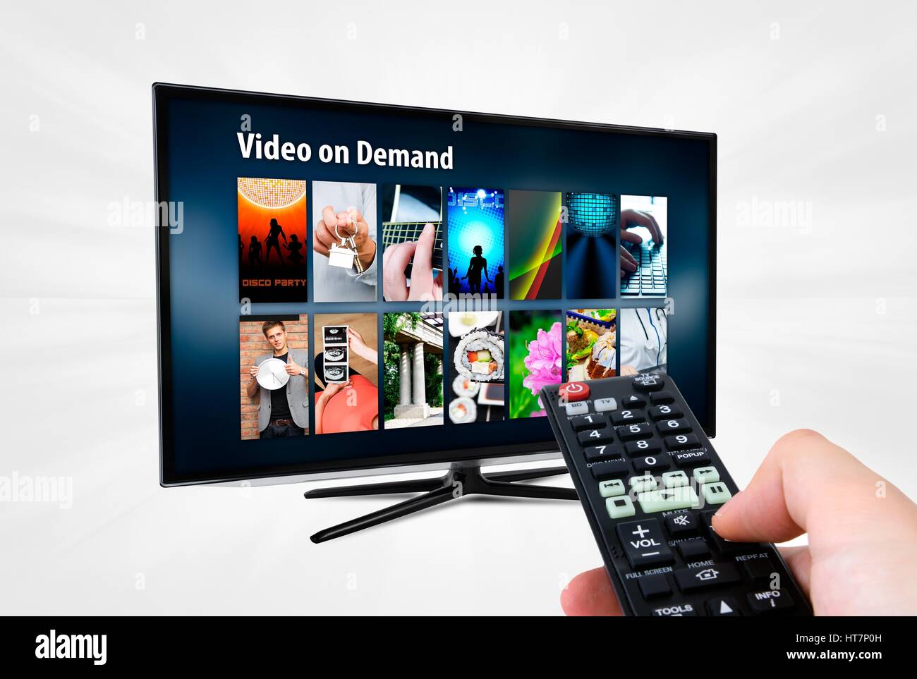 Video on demand VOD service on smart TV. Remote control in hand. Stock Photo