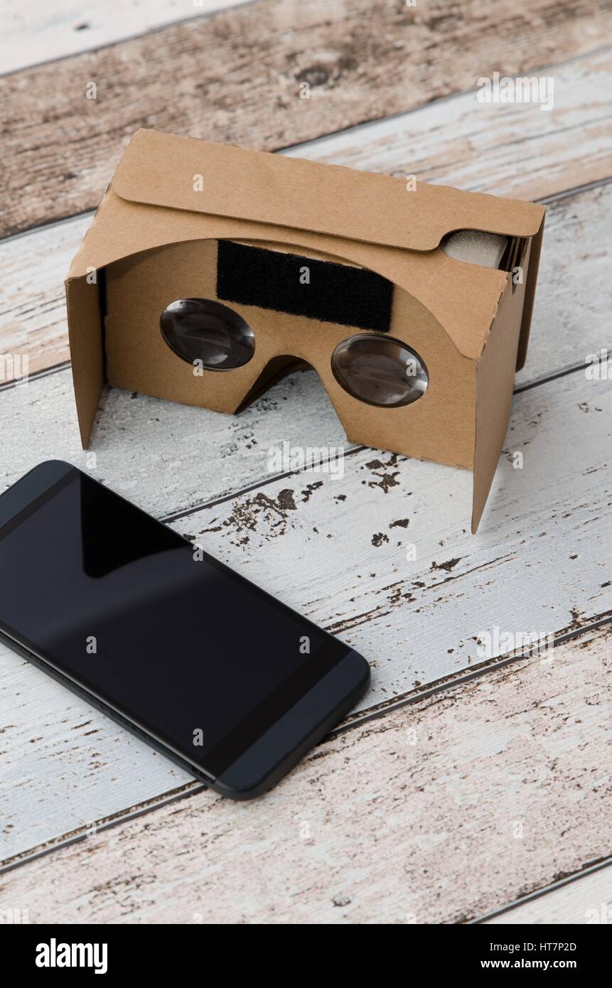 Virtual reality cardboard glasses. Easy way to watch movies in 3D. Shoot on  wooden background Stock Photo - Alamy