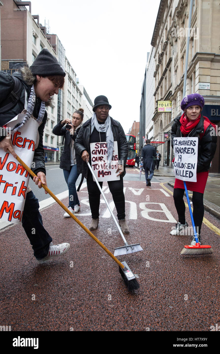 London, UK. 8th Mar, 2017. Women from Global Women's Strike and Women's Strike UK sweep the street as part of a protest for the world's mothers and children outside the Central Family Court in Holborn on International Women's Day and as part of an International Women's Strike. Brooms have been adopted as a symbol by women in the UK on the basis that brooms are strong when all strands work together. Credit: Mark Kerrison/Alamy Live News Stock Photo