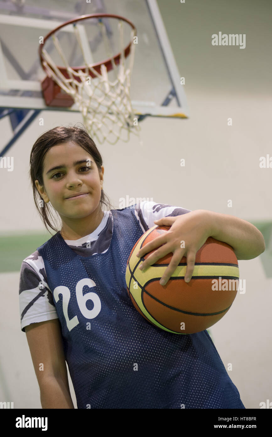 Girl standing with ball in basketball court Stock Photo Alamy