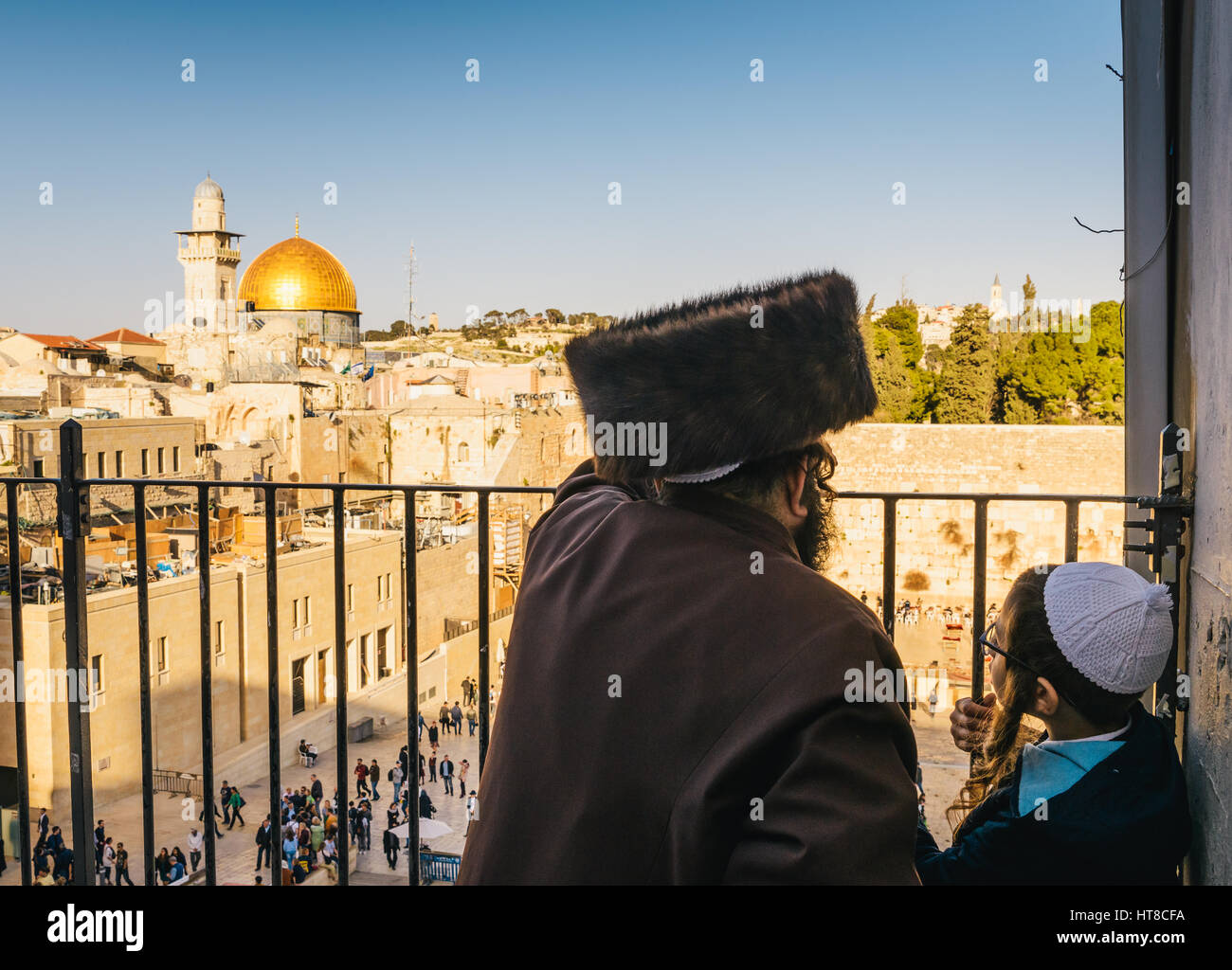 An orthodox Jewish man wearing a shtreimel and a boy overlook the Stock Photo