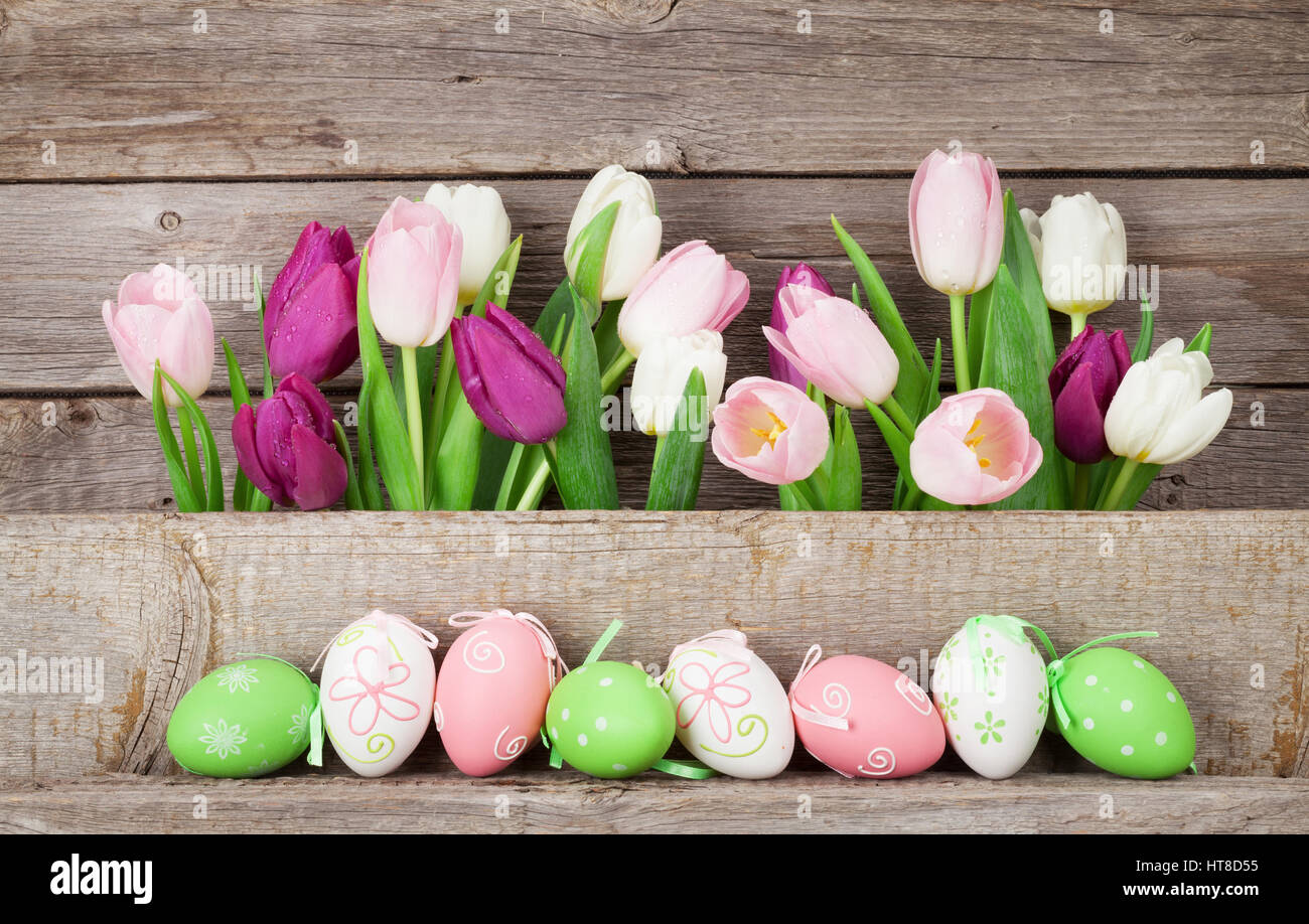 Easter eggs and colorful tulips in front of wooden wall Stock Photo - Alamy
