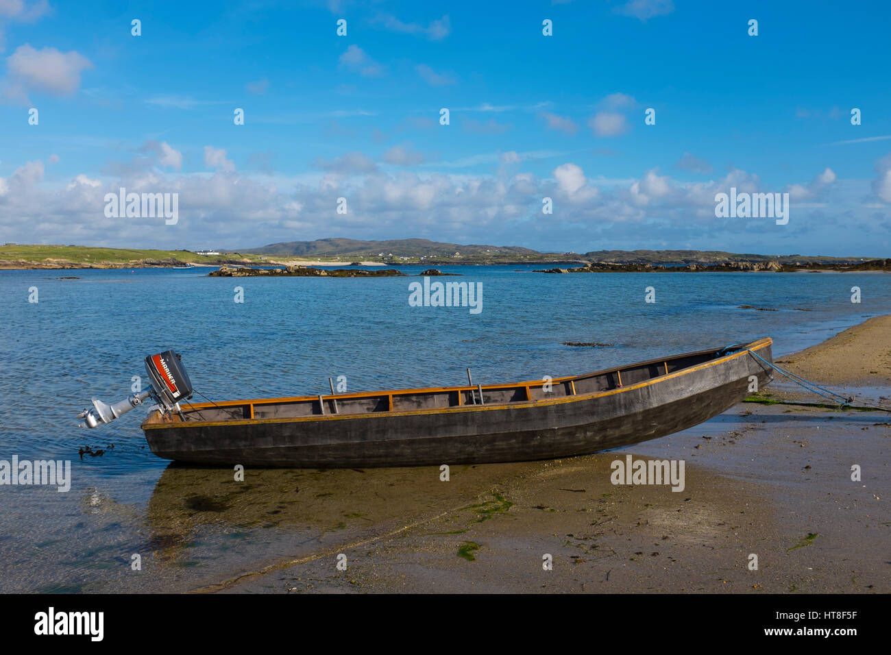 Traditional Curragh, canvas and wood boat on Omey Island at low tide, Connemara, Galway, Ireland. Omey is a tidal island - with a signposted route so  Stock Photo