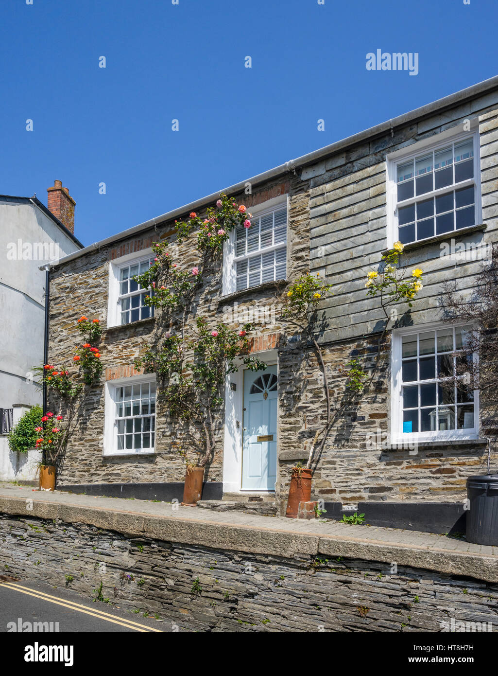 United Kingdom, South West England, Cornwall, Padstow, typical Cornish granite and slate house facade adorned with rose bushes Stock Photo