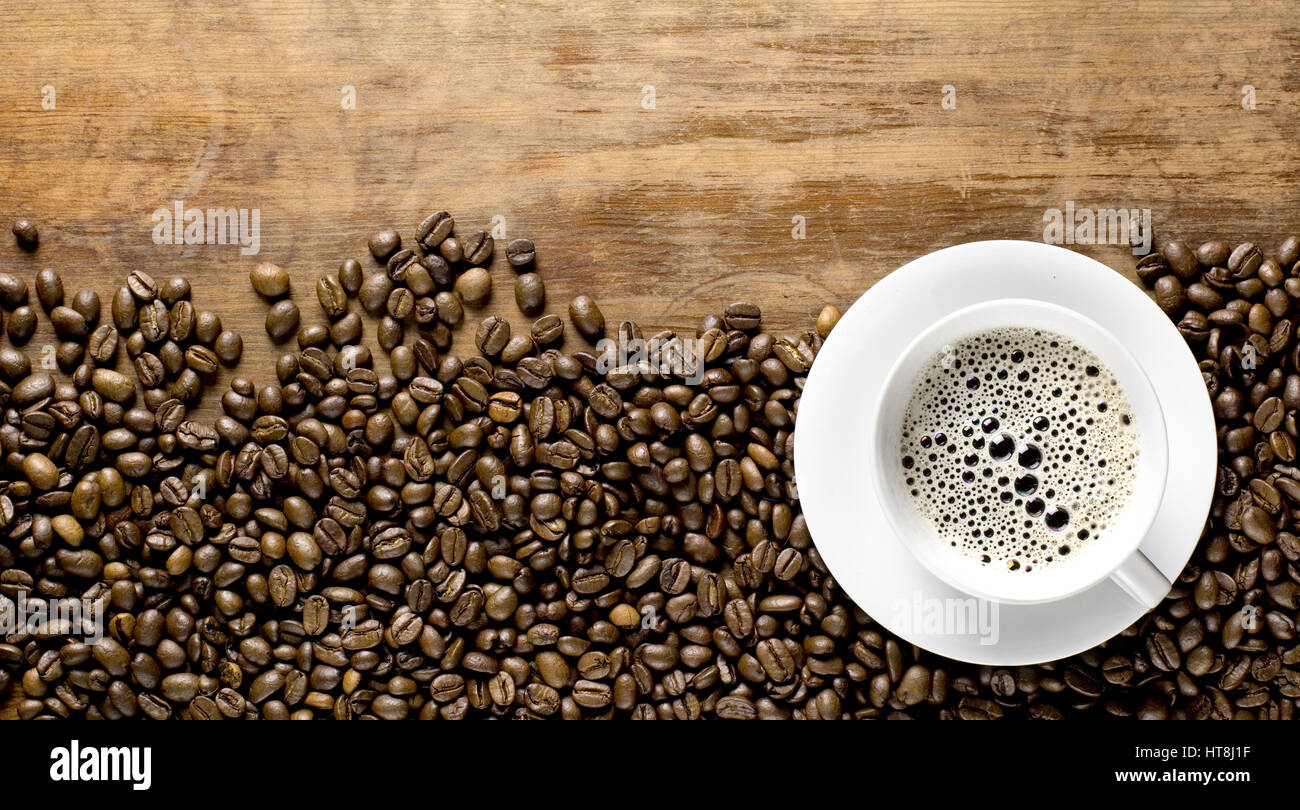 coffee beans background with cup on old rustic table Stock Photo - Alamy