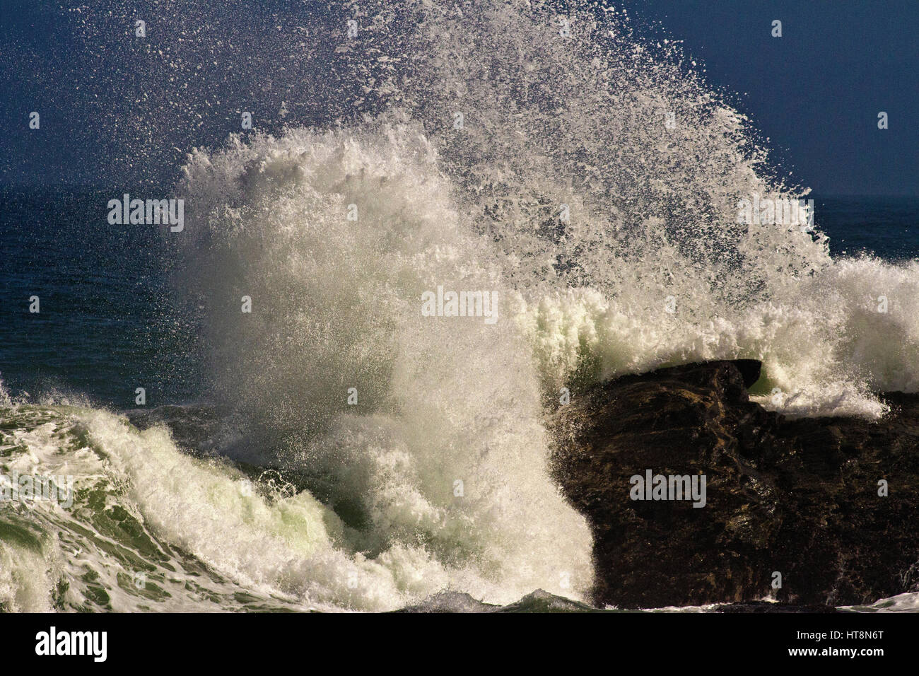 Spray from the waves hitting the rocks at Diaz Point, Luderitz, Namibia Stock Photo