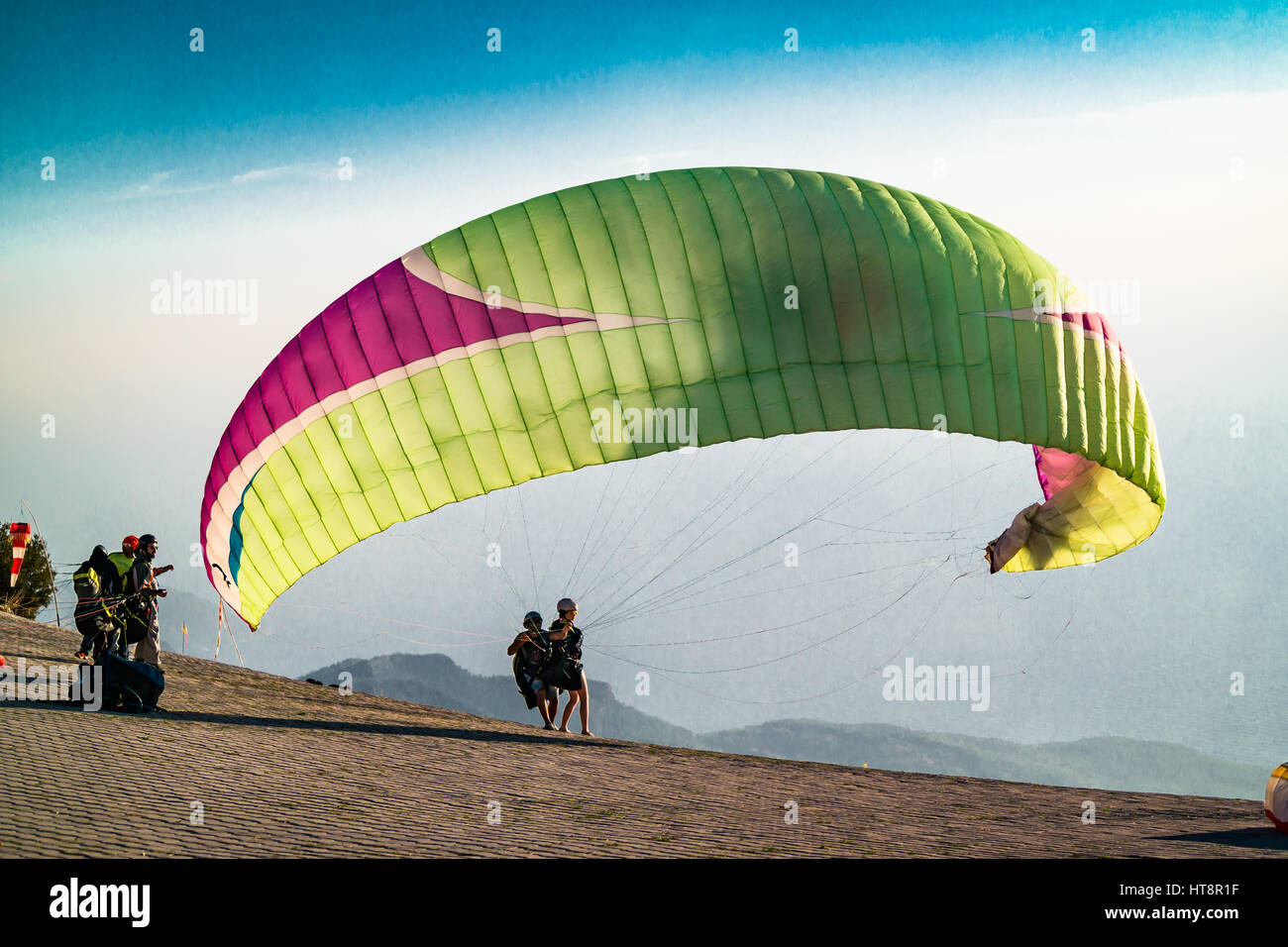 Tandem paragliding at take off ready to take off,canopy is filling with