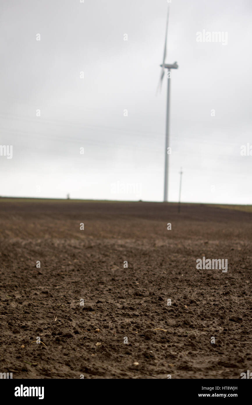 landscape with wind turbines and plowed soil on the empty field at the ...