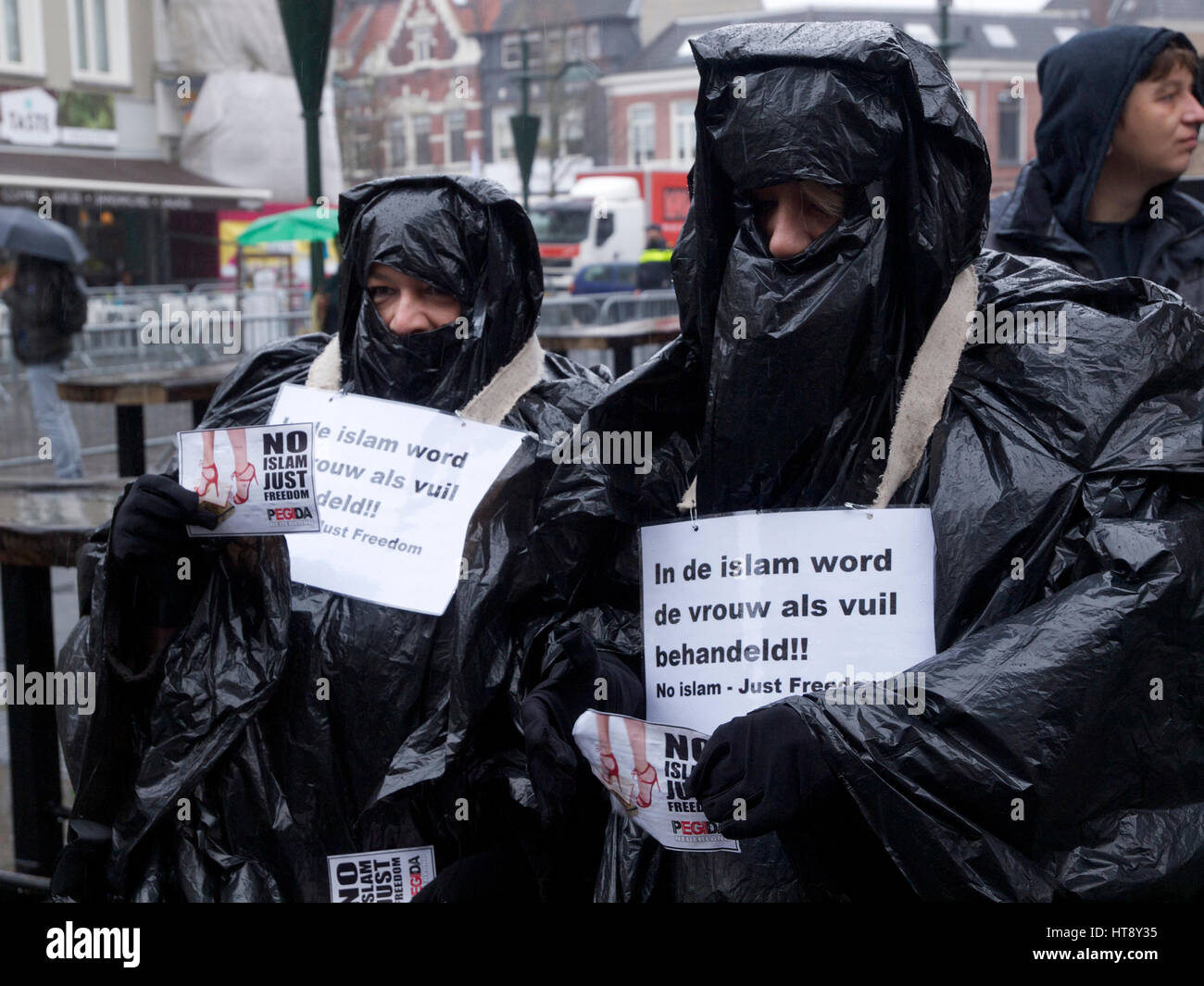 Women that support Pegida, against Islam, wearing a fake Burqa made from bin liners. Breda, the Netherlands. Islam treats women like garbage. Stock Photo