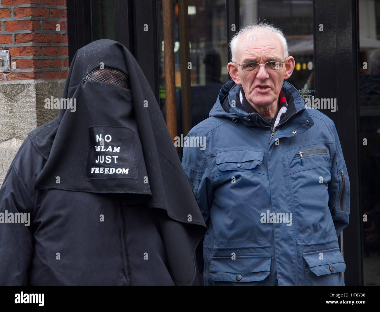 Pegida anti-islam protesting couple. No islam just freedom, the message on the burqa reads. Breda, the Netherlands Stock Photo