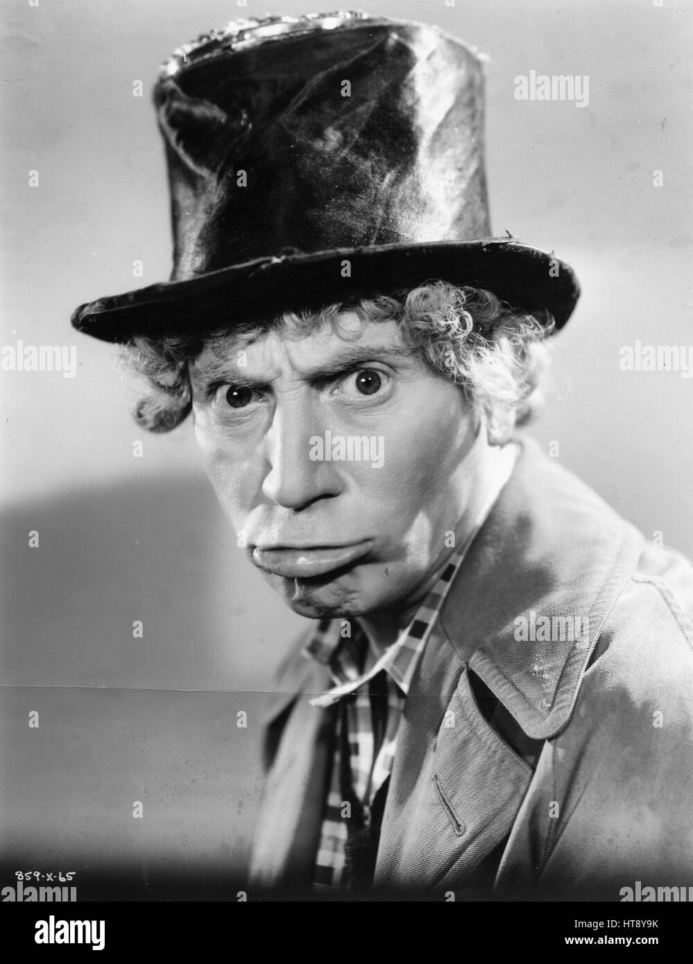'It isn't the Boogy man...It's merely Harpo Marx practicing making faces for 'A Night at the Opera,' the new Marx Brothers comedy produced by Irving G. Thalberg at Metro-Goldwyn-Mayer. Harpo finally scared himself so badly with a mean face that he ran and hid.' Stock Photo