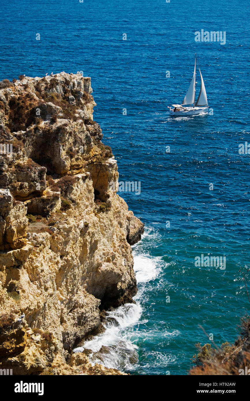 Sailboat and Cliffs at Lagos, Algarve Coast, Portugal Stock Photo
