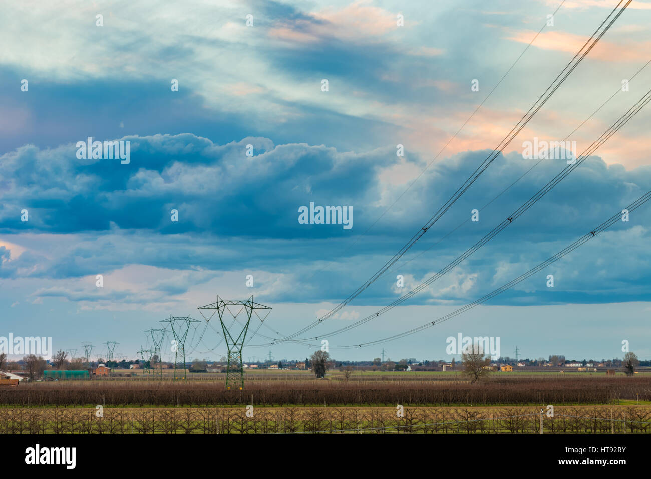 High voltage electricity pylons and power line in cultivated fields in