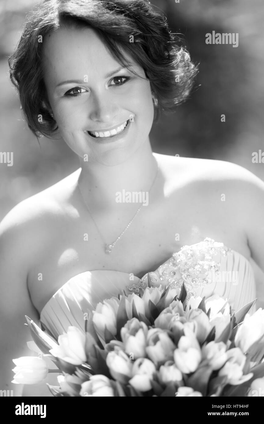 Portrait of a beautiful woman in holding bouquet of tulips. Black and ...