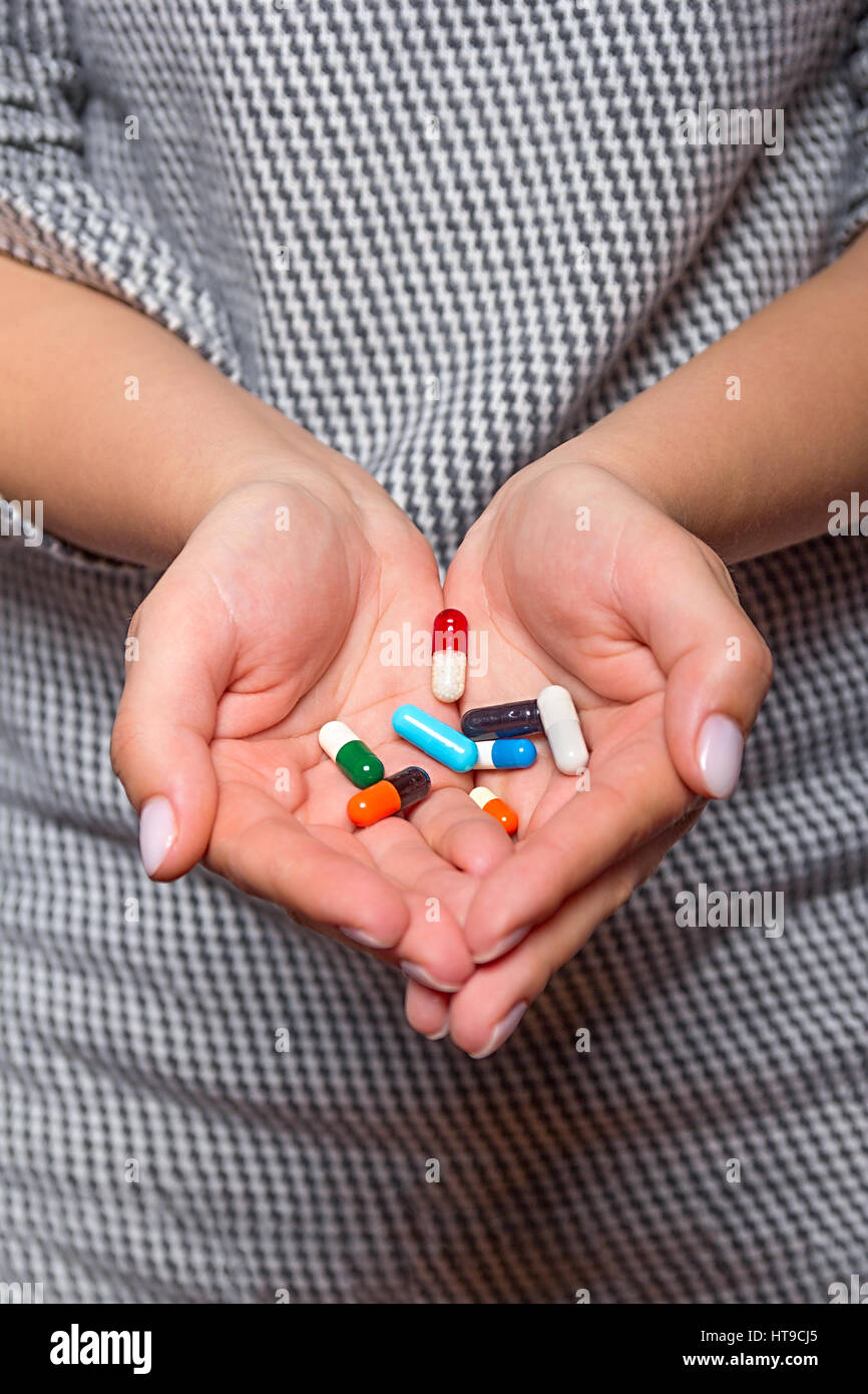 Woman arm holding heap of meds  before taking medication, focus on medicine Stock Photo