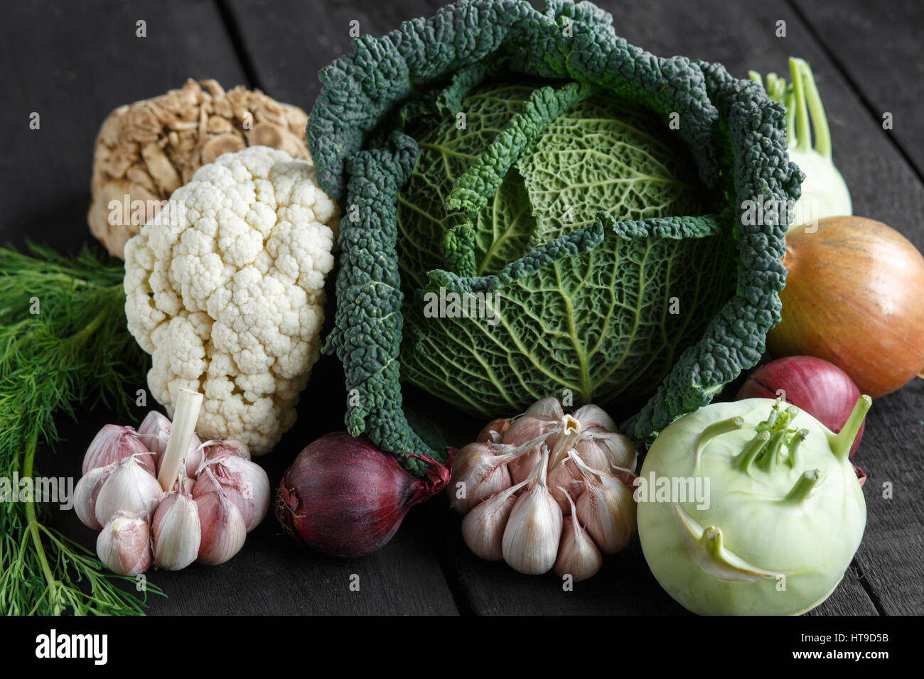 Spring vegetables on a dark background: Savoy cabbage, cauliflower ...