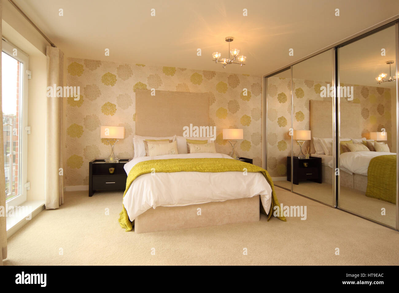 Home interior, modern bedroom, spacious, mirrored wardrobe, yellow cream decor, lamps, bedspread, throw, cushions, Stock Photo