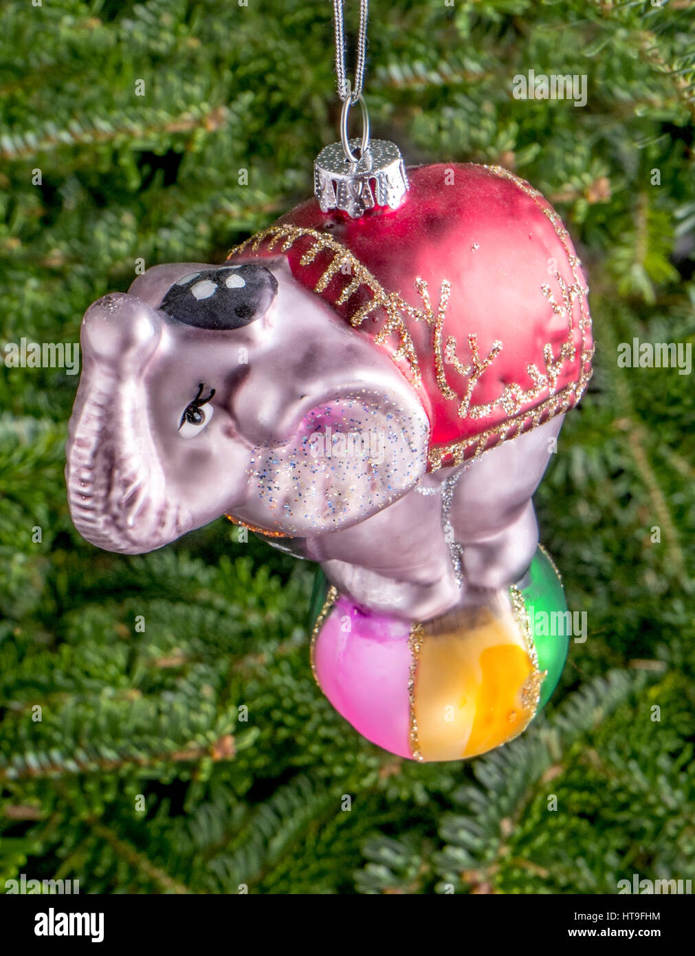 Christmas bauble hanging from a tree in the shape of a Circus Elephant balancing on a Ball Stock Photo