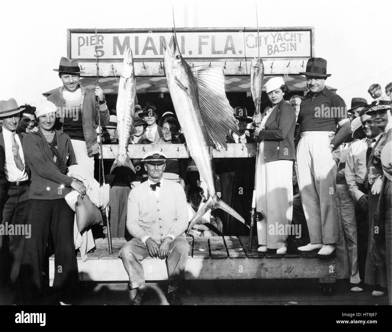 'Miami, FLA.: Freeman Gosden and Charles Correlle, known better over the radio as 'Amos N Andy,' are vacationing at Miami, Fla. Photo shows them with their wives at the city docks, following a thrilling fishing trip during which time they caught a giant sail fish, a barracuda and dolphin. (left) Mr. and Mrs. Amos. (Right Mr. and Mrs. Andy).' Stock Photo