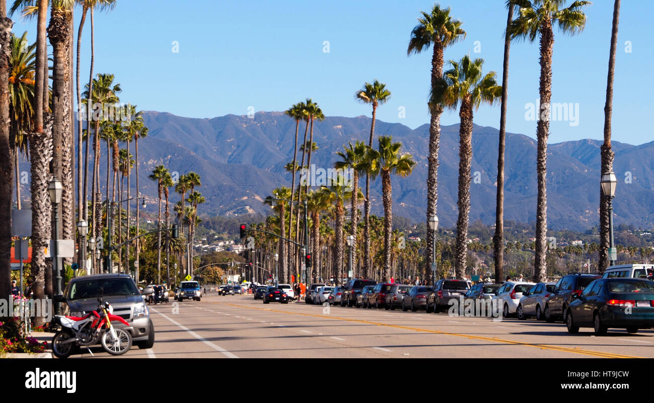 Santa Barbara, California USA with palm trees by roadside & mountain backdrop on a clear day with blue sky Stock Photo
