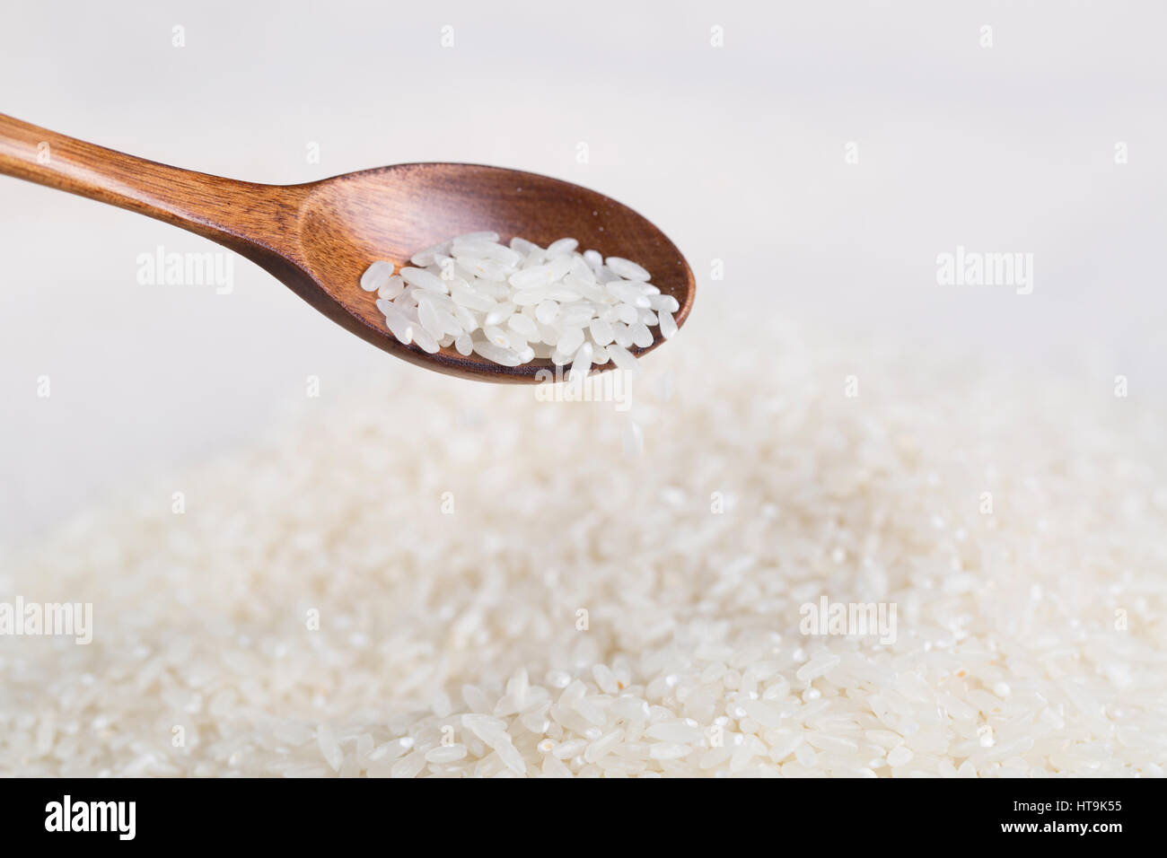Rice grains closeup on the wooden spoon Stock Photo - Alamy