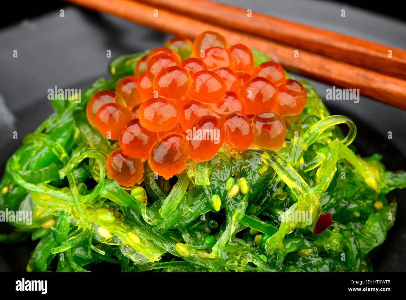 Japanese style raw salmon eggs so beautiful orange color put on japanese seaweed salad Stock