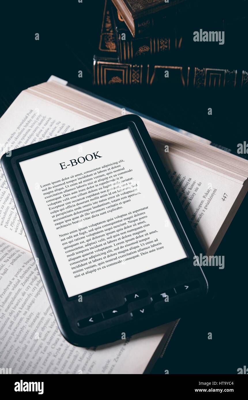 Ebook reader device on desk in library. Alternative for traditional