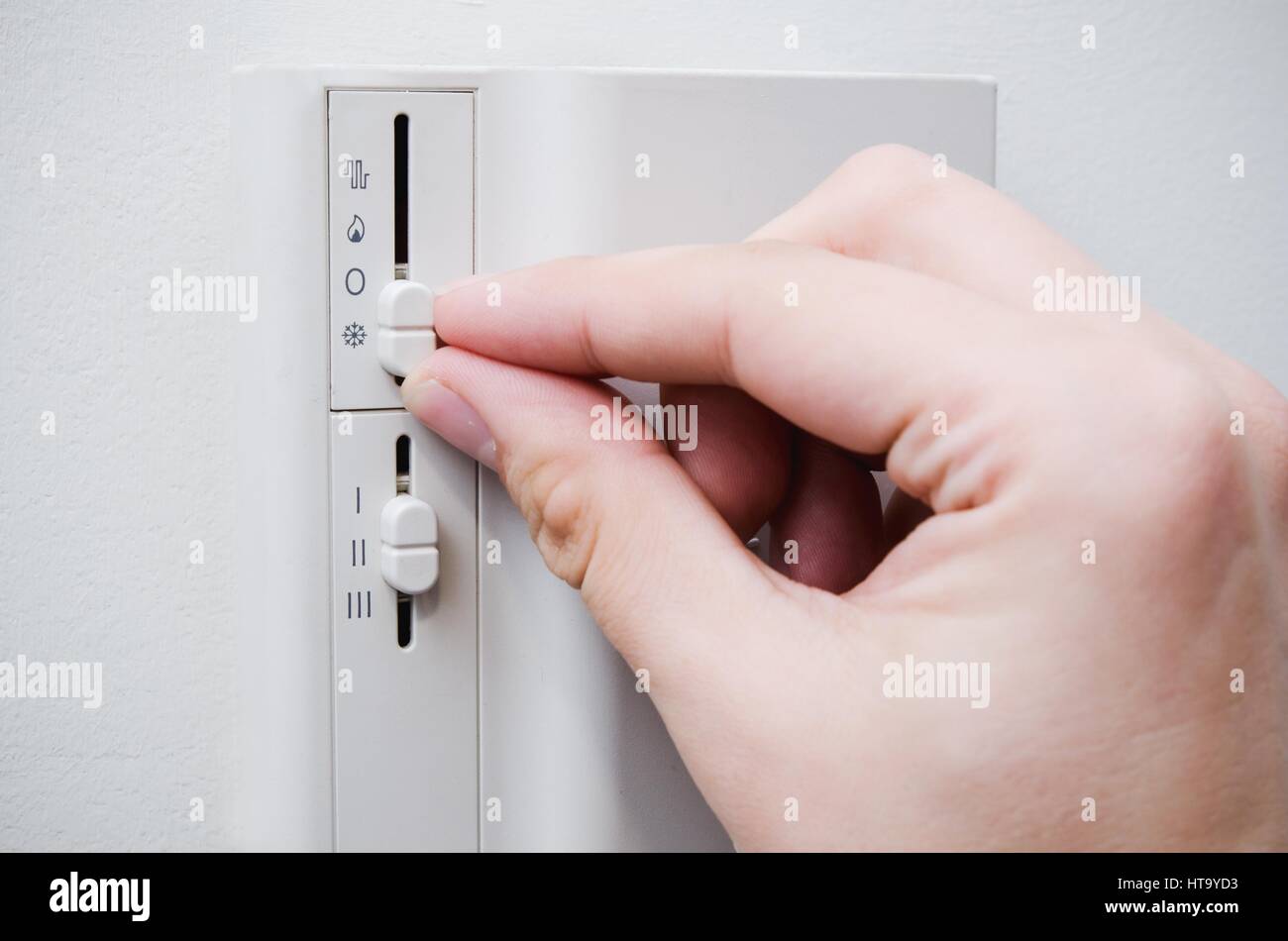 Hand switches air conditioner system thermostat on wall Stock Photo Alamy