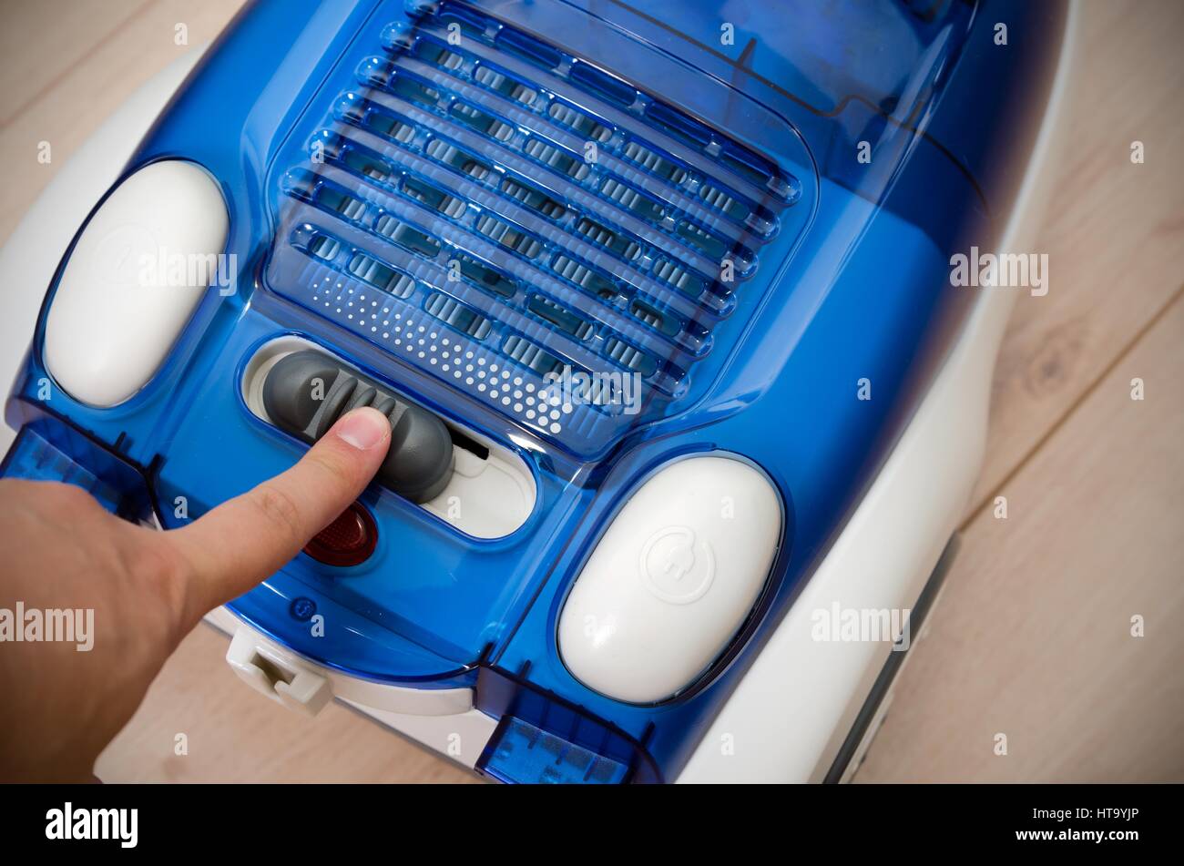Hand switch sets the power efficiency of the vacuum cleaner. Energy saving and efficiency appliances. Stock Photo