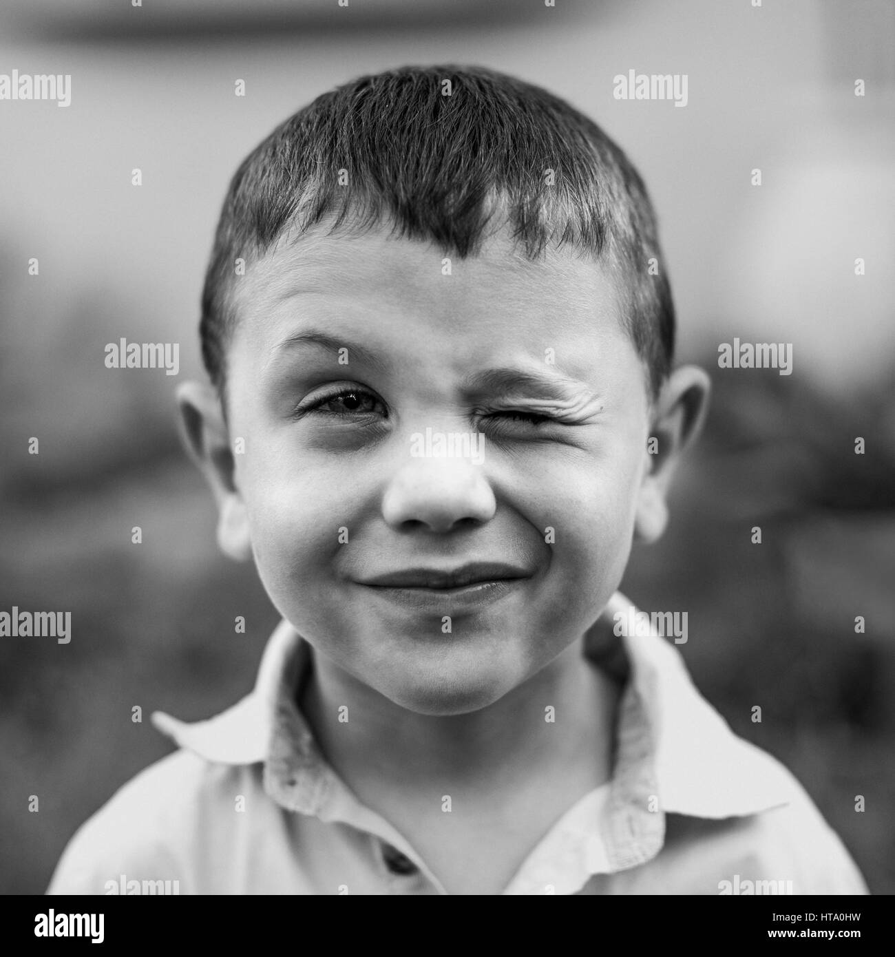Black and white portrait of a winking boy Stock Photo