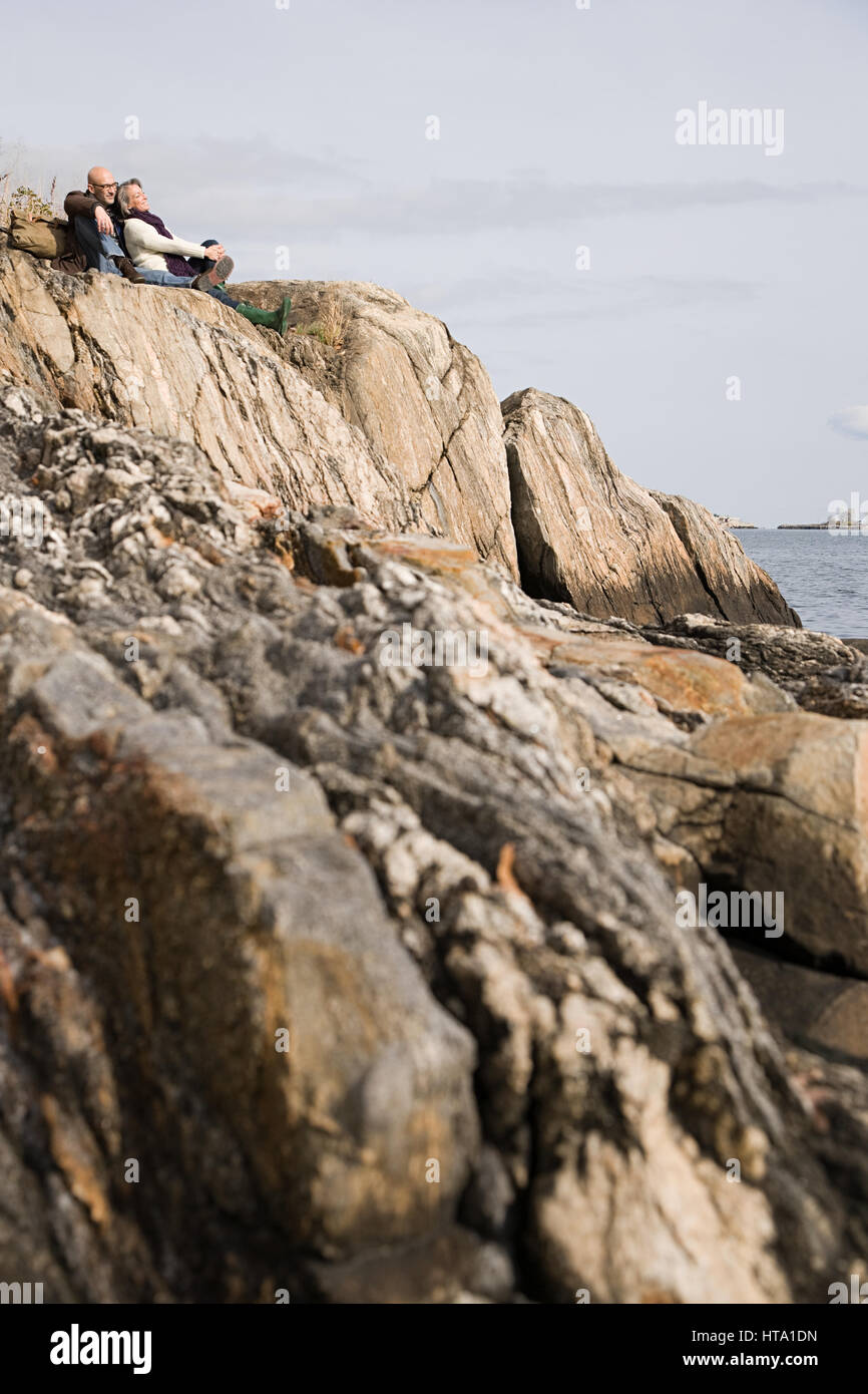 Resting On Rocks Mature couple resting on rocks Stock Photo - Alamy