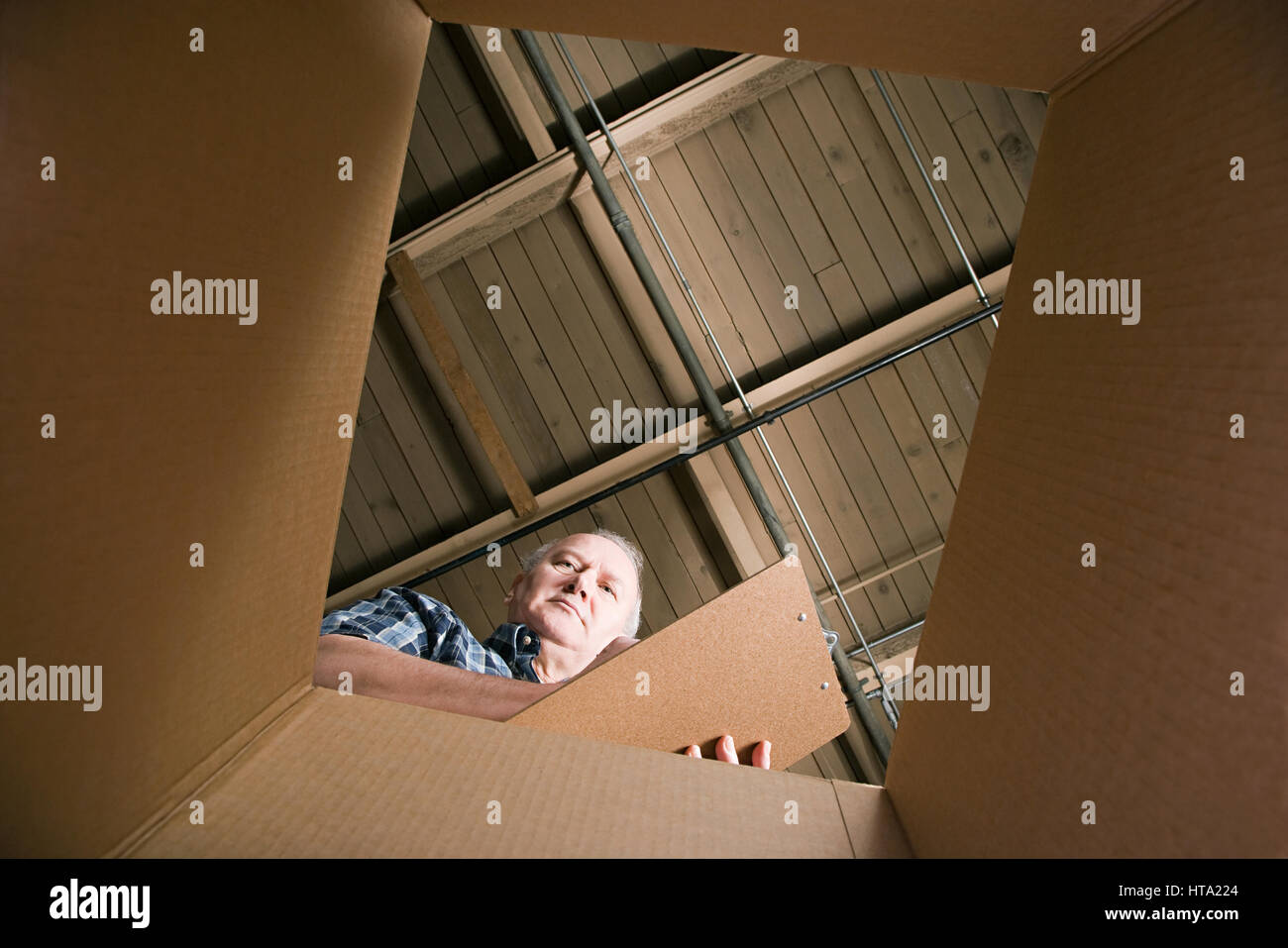 Man looking in cardboard box Stock Photo