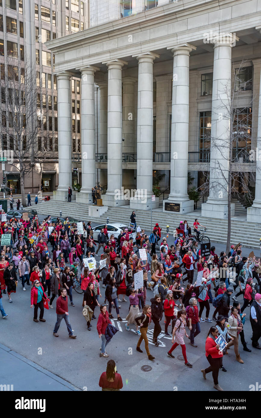 San Francisco, USA. 8th Mar, 2017. Demonstrators march through San Francisco toward ICE headquarters to protest Trump's deportation of undocumented immigrants after a rally on International Women's Day. Many demonstrators wore red to show support for the 'Day without a Woman' strike. Credit: Shelly Rivoli/Alamy Live News Stock Photo