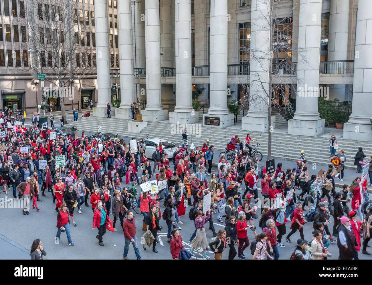 San Francisco, USA. 8th Mar, 2017. Demonstrators march past the old Federal Reserve building toward San Francisco ICE headquarters to protest Trump's deportation of undocumented immigrants after a rally on International Women's Day. Many demonstrators wore red to show support for the 'Day without a Woman' strike. Credit: Shelly Rivoli/Alamy Live News Stock Photo