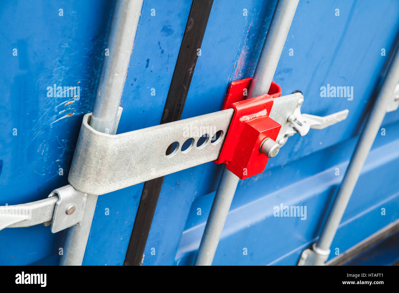 Red lock on the gate of standard blue cargo container for shipping transportation Stock Photo