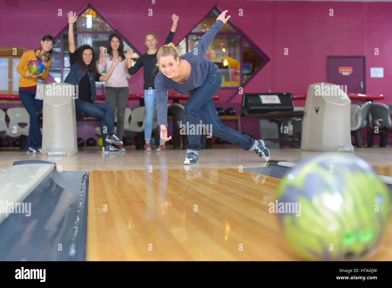 Woman throwing bowling ball Stock Photo