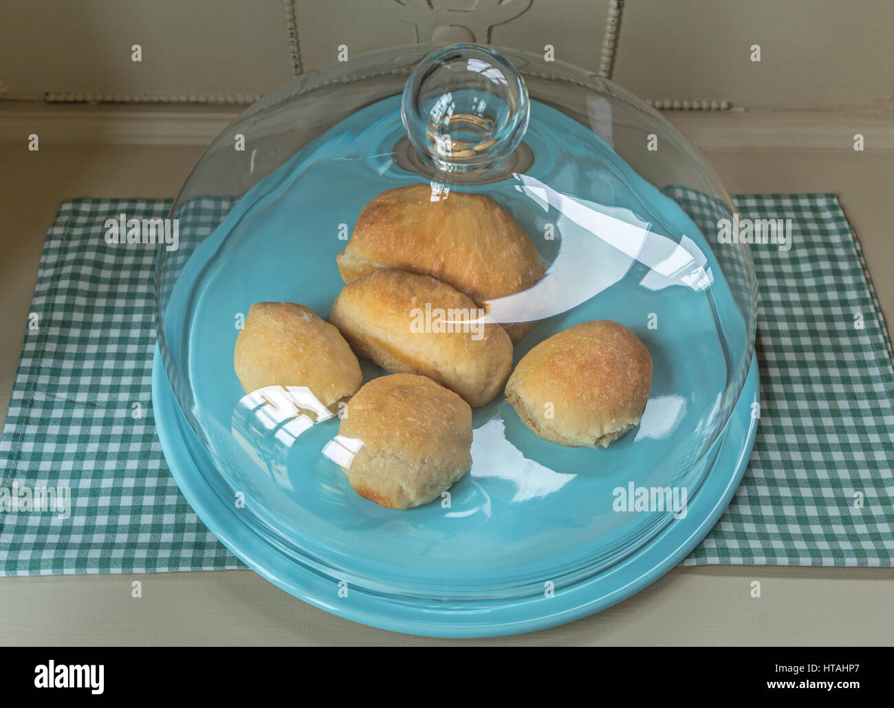 Home baked bread rolls on a glass topped cake stand. Stock Photo